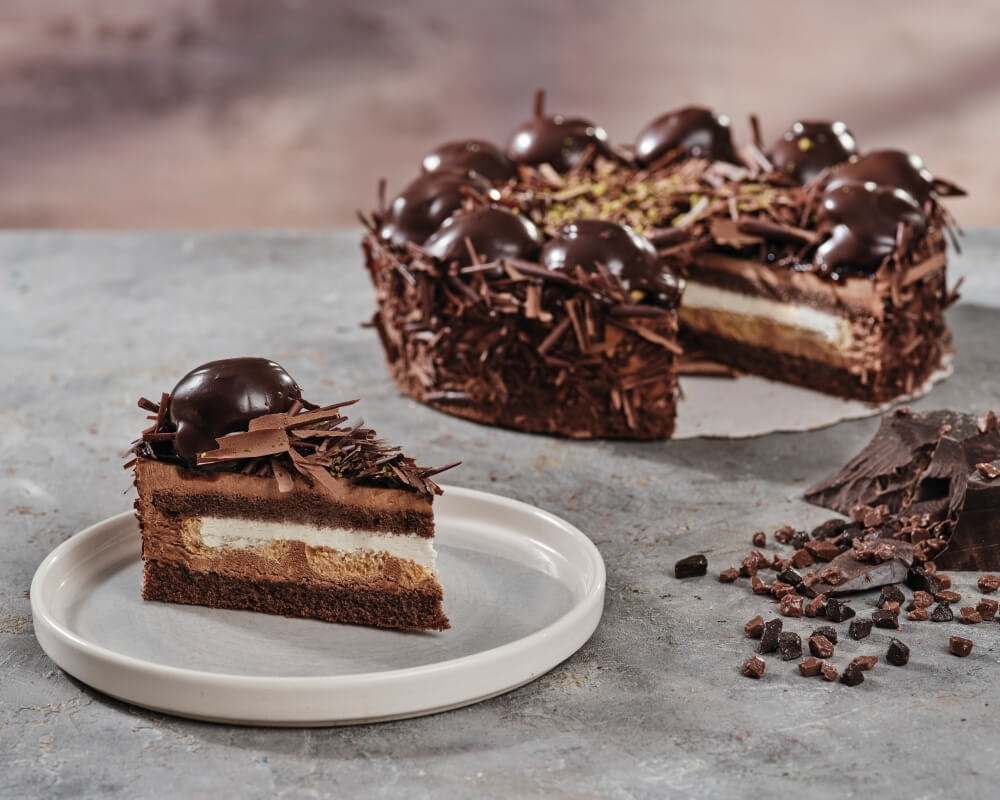 Siyah Profiterollü Pasta Kakaolu kek, kremalı profiterol topları ve bitter çikolata sosu ile eşsiz bir lezzet. Yoğun çikolata severler bu tad tam da size göre.